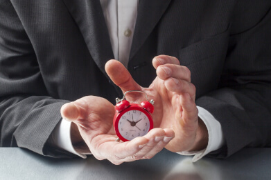 Business man holding a small clock